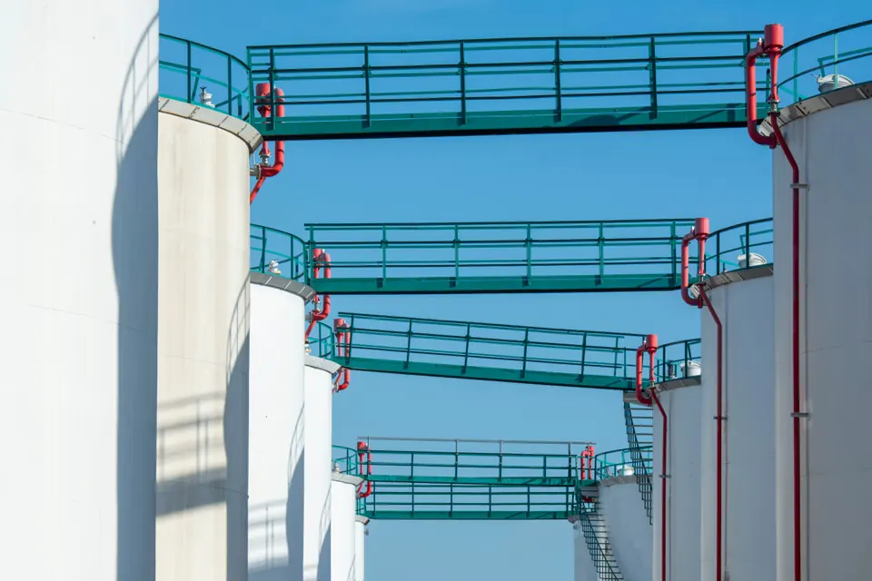 A sequence of storage tanks linked by elevated access platforms