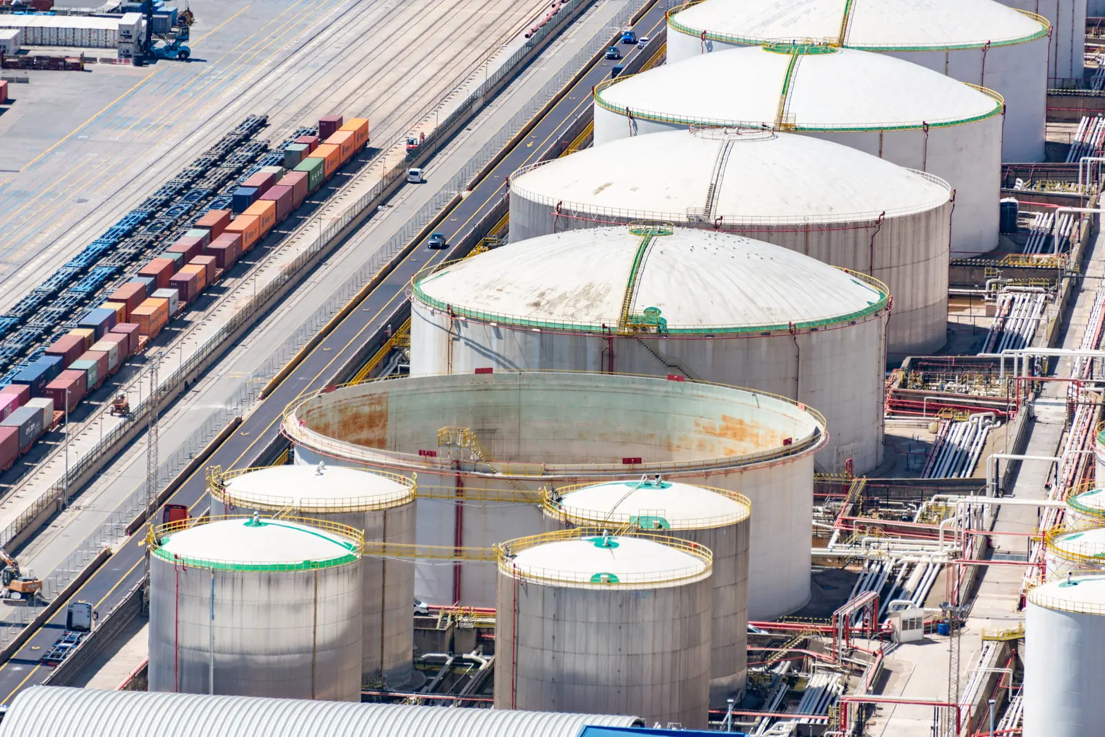 An elevated view of storage tanks beside rail and port infrastructure